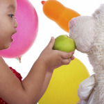 Kid Having Fun Feeding Her Teddy An Apple