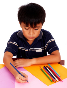 Boy With His Colored Pencils Drawing A Picture